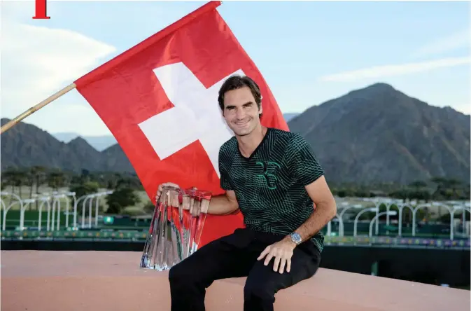  ?? —AFP ?? INDIAN WELLS: Roger Federer of Switzerlan­d along with his BNP Paribas Open trophy poses for photograph­ers after defeating Stan Wawrinka of Switzerlan­d during the men’s final of the BNP Paribas Open at the Indian Wells Tennis Garden on Sunday in Indian...