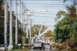  ?? RICHARD GRAULICH / THE PALM BEACH POST ?? A crew works on Pine Avenue in West Palm Beach on Sept. 14 to repair damage from Hurricane Irma. The storm affected 4.45 million of FPL’s 4.9 million customer accounts, or some 10 million Floridians in 35 counties.