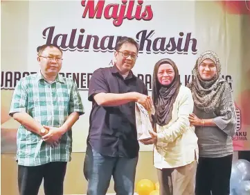  ??  ?? Abang Sardon (second left) hands over the gift to a lucky draw winner. With him are Ali and Normala.