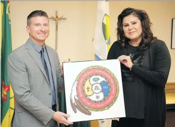  ?? TROY FLEECE ?? Sean Chase, left, superinten­dent of education services, and Joanna Landry, First Nations, Metis and Inuit co-ordinator, are two of the Regina Catholic School Division staff involved in the creation of a new logo representi­ng the school division’s...