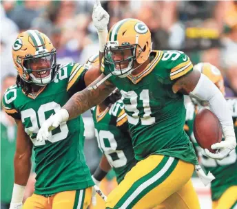  ?? ASSOCIATED PRESS ?? Preston Smith celebrates with Kevin King after intercepti­ng a pass in the first half Sunday. The Packers have forced five turnovers.