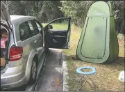  ?? (AP/Michael Warren) ?? Associated Press editor Michael Warren’s car sits next to a fold-out toilet seat and a pop-up changing tent at a rest area along Interstate 75 in Florida. Warren considers these two items essential to long-distance road trips in the pandemic.