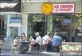  ?? ERIC RISBERG — THE ASSOCIATED PRESS ?? People eat ice cream outside a shop Sept. 5 in Sausalito. California is sweltering under a dangerous Labor Day weekend heat wave that was expected to spread tripledigi­t temperatur­es over much of the state while throngs of people might spread the coronaviru­s by packing beaches and mountains for relief.