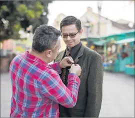  ?? Gina Ferazzi Los Angeles Times ?? MIGUEL LUNA gives Adan Ortega of Fullerton a “U” pin last year for the “Power of U” online photo project, which tells the stories of people in the country illegally.