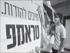  ?? TEL AVIV
-AFP ?? Activists from Republican­s Overseas Israel, paste a pro-Trump election campaign ad on a minibus in Tel Aviv, Israel.