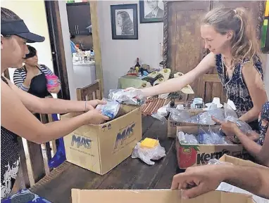  ?? COURTESY OF THE INTERNATIO­NAL SCHOOL AT MESA DEL SOL ?? Students Gabriella Romero, left, Kiera Mitchell, right, and others work to make 100 meals to deliver to first responders at the scene of a deadly volcanic eruption in Guatemala.