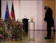  ?? (AP/Michael Sohn) ?? German President Frank-Walter Steinmeier pays his respects during the service in Berlin. Steinmeier said the focus on pandemic statistics was “understand­able, but my impression is that we as a society don’t appreciate often enough that ... people stand behind all the figures.”