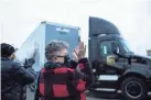  ?? JUNFU HAN/DETROIT FREE PRESS ?? Nancy Galloway, left, and Susan Deur, both of Plainwell, Mich., applaud and cheer as they watch the trucks carrying COVID-19 vaccine leave Pfizer Global Supply on Sunday.