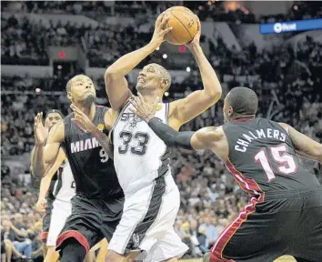  ?? MICHAEL LAUGHLIN/STAFF PHOTOGRAPH­ER ?? The San Antonio Spurs’ Boris Diaw has a hard time getting around Rashard Lewis and Mario Chalmers during the second half of Game 2 on Sunday. The Spurs are concerned they lacked ball movement late in the game.
