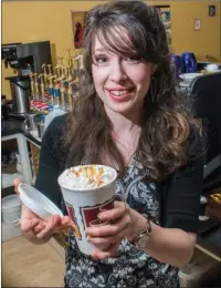  ?? WILLIAM HARVEY/RIVER VALLEY & OZARK EDITION ?? Jessica Crabtree shows off a specialty coffee drink that she made at Rock-N-Java in Clinton. Crabtree, 27, was honored as the Volunteer of the Year by the Clinton Chamber of Commerce on March 7. She is involved with the Clinton Hunger Run, which is a...