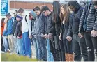  ??  ?? Students in Paducah, Ky., pray for the victims of the Marshall County High School shooting. MICHAEL CLEVENGER/USA TODAY NETWORK