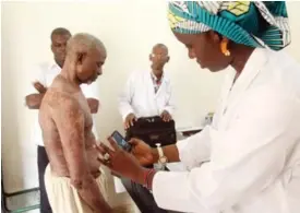  ?? — AFP ?? KOULIKOURO: A doctor of a health centre in Koulikoro takes pictures of a patient suffering from a skin disease.