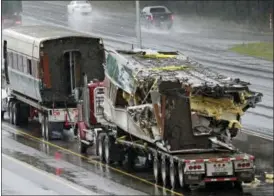  ?? ELAINE THOMPSON — THE ASSOCIATED PRESS ?? Two damaged train cars sit on flatbed trailers after being taken from the scene of an Amtrak train crash onto Interstate 5a day earlier Tuesday in DuPont, Wash.