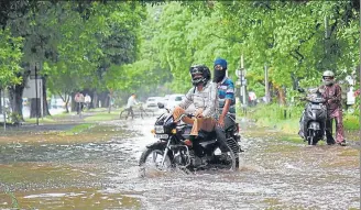  ?? HT PHOTO ?? ■
Two-wheeler riders struggle to get through a waterlogge­d spot in Sector 9 after a heavy spell of rain in June this year.
