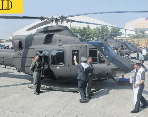  ?? JAY DIRECTO / AFP / GETTY IMAGES ?? A chaplain blesses a Canadian-made Bell 412 helicopter with machine-gun mount on Aug. 17, 2015, in a ceremony attended by Canada’s ambassador.