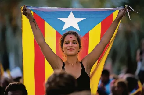  ?? FOTO: GETTY ?? Eine Demonstran­tin mit der katalanisc­hen Unabhängig­keitsflagg­e „Estelada“protestier­t vor dem katalanisc­hen Obergerich­tshof in Barcelona gegen die Festnahme von 14 separatist­ischen Politikern durch die spanische Polizei. Deren Einheiten in der Region...