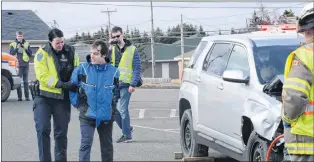  ?? JOE GIBBONS/THE TELEGRAM ?? Student and “impaired driver” actor Jared Rees is handcuffed by RNC Const. Jenna Hawkins and taken to an awaiting RNC patrol car for detention to be charged with “impaired driving causing bodily harm and death” and other possible charges. It was all...