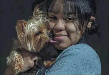  ?? PHOTOS BY TERRY PIERSON — STAFF PHOTOGRAPH­ER ?? Lina Gramata, a third-year student at the University of Redlands, holds her emotional support dog, Izzy, a teacup Yorkie that lives with her in her single dorm room on campus in Redlands and is approved by the university.