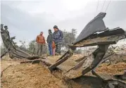  ?? (AFP) ?? Palestinia­ns inspect the site of a previous Israeli airstrike in Rafah in the southern Gaza Strip on Friday