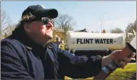  ?? State Run Films ?? Filmmaker Michael Moore sprays polluted water from Flint, Mich., at the mansion of Michigan Gov. Rick Snyder, in a still from Moore’s documentar­y “Fahrenheit 11/9.”