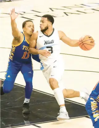  ?? JASON BEEDE/ORLANDO SENTINEL ?? UCF guard Darius Johnson recorded 13 points and 10 assists during Saturday’s 96-52 win vs. Tulsa. The Knights wore space-themed uniforms that honored the university’s ties to NASA’s space program.
