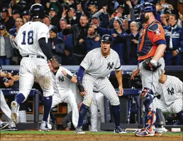  ?? AL BELLO / GETTY IMAGES ?? Aaron Judge (center) celebrates as he and Didi Gregorius (left) score on a two-run, tiebreakin­g double by Gary Sanchez in the eighth inning of the Yankees’ 6-4 win over the Astros in Game 4 of the ALCS.