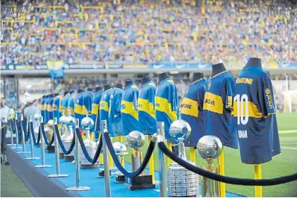  ??  ?? Se miran y no se tocan. En el campo de juego, las copas internacio­nales ganadas por Boca en su historia.