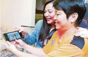  ?? PIC BY L. MANIMARAN ?? Cheong Jun Hoong’s mother, Leow Lai Kuan, and her sister, Jun Yeng, watching her on the podium at the World Aquatics Championsh­ip in Hungary on Wednesday.