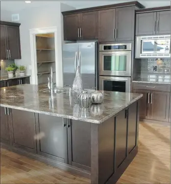  ?? JEFF LYONS/THE Starphoeni­x photos ?? TOP LEFT: Double doors leading to the master suite are one of the home’s outstandin­g style features. MIDDLE LEFT: Casual and elegant is how Trendsette­r Homes describes its new 2,199-squarefoot home. ABOVE: The kitchen at 1210 Patrick Cove features a...