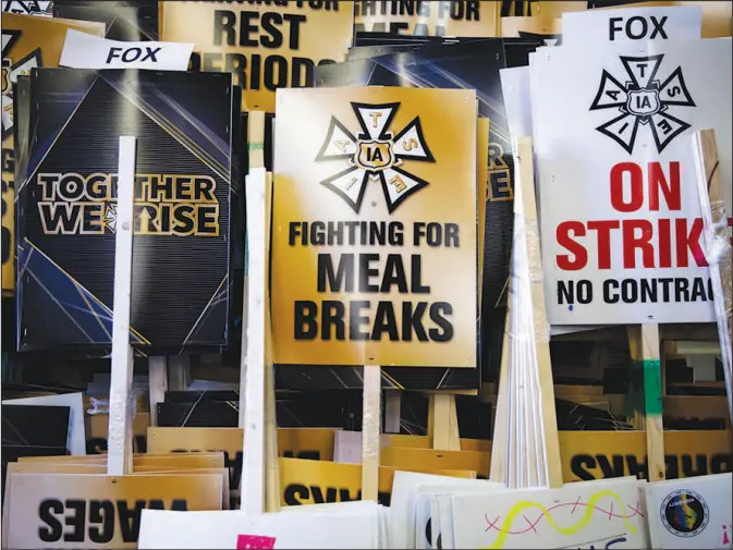  ?? JENNA SCHOENEFEL­D / THE NEW YORK TIMES ?? Bundles of strike protest signs sit Oct. 16 at the Internatio­nal Cinematogr­aphers Guild building in Los Angeles, where the Internatio­nal Alliance of Theatrical Stage Employees were prepared for a strike before negotiator­s reached tentative agreements with film and television studios. The pandemic’s economic disruption has given workers new leverage, contributi­ng to a recent upturn in strikes.