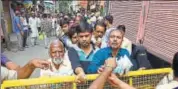  ?? PRABHAKAR KUMAR/HT ?? Walled City residents queue up to buy milk as police officials keep watch, in Jaipur on Sunday.