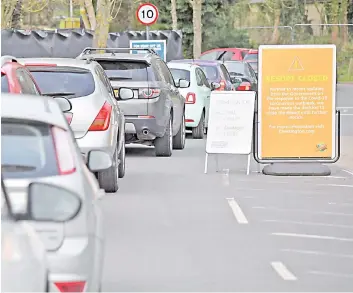  ?? — AFP photo ?? NHS workers queue up at a drive-in facility to test for the novel coronaviru­s Covid-19, set up in the carpark of Chessingto­n World of Adventures in Chessingto­n, Greater London.