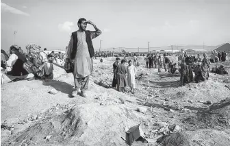  ?? Jim Huylebroek / New York Times ?? People gather near the airport in Kabul, Afghanista­n. Despite a security warning from the U.S. Embassy, crowds of people wanting to leave the country remain outside the airport.