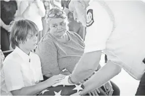  ?? MICHAEL A. SCHWARZ, USA TODAY ?? Stephen Akins’ son, Skylar, and mother, Chrystal Akins, receive a flag from Doug Robbins, part of an American Legion Honor Guard, at the former soldier’s funeral at Georgia National Cemetery on Julyly 9.