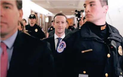  ?? FOTO: AFP ?? Der Chef des sozialen Netzwerkes Facebook, Mark Zuckerberg, wird bei seinem Besuch im US-Kongress von Sicherheit­skräften begleitet.