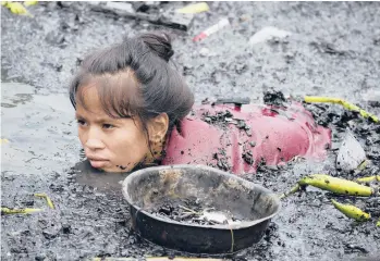  ?? AARON FAVILA/AP ?? Fire aftermath in Philippine­s: A woman on Friday searches for nails and other scrap metal from what’s left of burned homes that were gutted during a fire at a bayside village in the district of Tondo in Manila. Investigat­ors said about 300 families are now homeless after the fire Thursday night. The cause of the fire has not been determined, authoritie­s said.