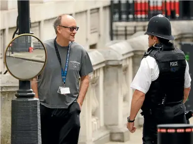  ?? AP ?? Dominic Cummings, chief adviser to Britain’s Prime Minister Boris Johnson, chats to a police officer in Downing Street, London. Cummings is backing new technology to capture carbon in the atmosphere and store it undergroun­d to assist in the battle against climate change and to help meet Britain’s 2050 commitment on emissions.