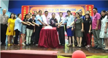  ??  ?? Lau (centre) cuts the Teacher’s Day celebratio­n cake with the members of the school board.