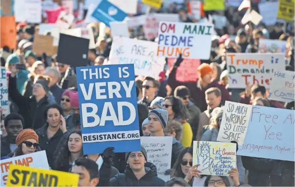  ?? PHOTOS BY MOLLY RILEY/ AFP/ GETTY IMAGES ?? Demonstrat­ors march on Pennsylvan­ia Avenue in Washington on Saturday while protesting President Trump’s recent action on refugees entering the U. S.