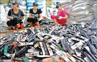  ?? JOHANNES EISELE/AFP ?? Workers dismantle electronic waste at a workshop in Guiyu Township in Shantou City, south China’s Guangdong.