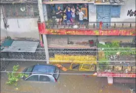  ?? PTI ?? ■ Flood-affected residents of Patna’s Bahadurpur area look on from their home on Sunday. Several areas in the Bihar capital were inundated, with the city receiving 152mm of rain the night before.