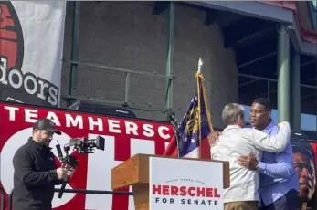  ?? Associated Press ?? Georgia Gov. Brian Kemp campaigns Saturday alongside Senate candidate Herschel Walker in Smyrna, Ga. Mr. Walker faces Sen. Raphael Warnock in a Dec. 6 runoff.