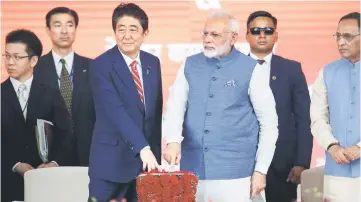  ??  ?? Abe (left) and Modi press a button at the groundbrea­king ceremony for a high-speed rail project in Ahmedabad, India. — Reuters photo