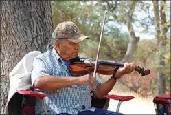  ?? JON HAMMOND / FOR TEHACHAPI NEWS ?? Luther playing his father’s fiddle at a place called Woodchoppe­r on the Rankin Ranch in Walker Basin, where the Girado family once lived in a cabin.