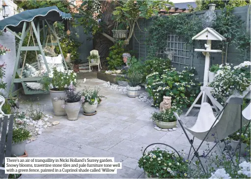  ??  ?? There’s an air of tranquilli­ty in Nicki Holland’s Surrey garden. Snowy blooms, travertine stone tiles and pale furniture tone well with a green fence, painted in a Cuprinol shade called ‘Willow’
