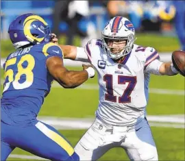  ?? Adrian Kraus Associated Press ?? BILLS QUARTERBAC­K Josh Allen (17) has the physical presence to use the stiff arm to ward off rushing defenders such as Rams linebacker Justin Hollins.