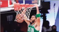  ?? Mark J. Terrill / Associated Press ?? The Boston Celtics’ Jayson Tatum dunks the ball during the first half against the Miami Heat during Saturday’s playoff game in Lake Buena Vista, Fla.