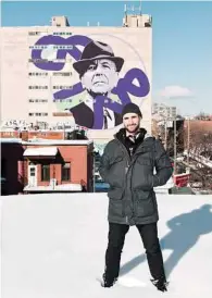 ??  ?? Kevin Ledo stands before the nine-story mural of the late Leonard Cohen he painted in the PlateauMon­t-Royal neighborho­od of Montreal. More than a year after the singer-songwriter died, Cohen commands a form of devotion.