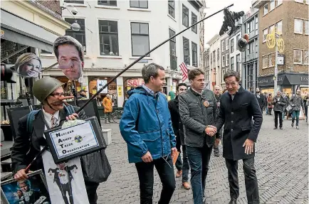  ?? PHOTO: GETTY IMAGES ?? An anti-war protester heckles Dutch Prime Minister Mark Rutte, right, as he campaigns in the Hague yesterday ahead of the Netherland­s general election. The vote is expected to be a close race between Rutte’s Liberals and Geert Wilders’ Party for Freedom.