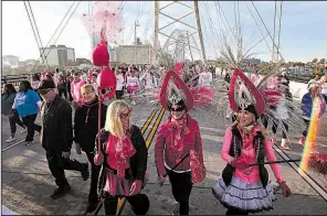  ?? Arkansas Democrat-Gazette/THOMAS METTHE ?? Sue Melton (bottom left) laughs with Star Akel (center) and Sheri Collazo as they cross the Broadway bridge during Saturday’s Race for the Cure.